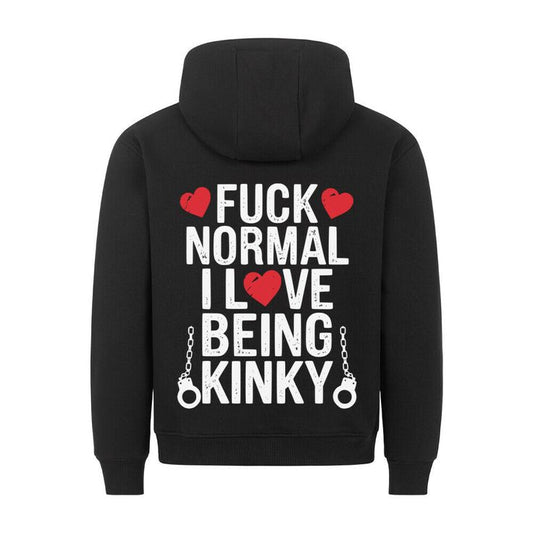 Persoon met rug naar de camera draagt een zwarte hoodie met gedurfde witte en rode tekst: 'FUCK NORMAL I LOVE BEING KINKY', afgewerkt met hartjes en handboeien, tegen een ruwe betonnen achtergrond.