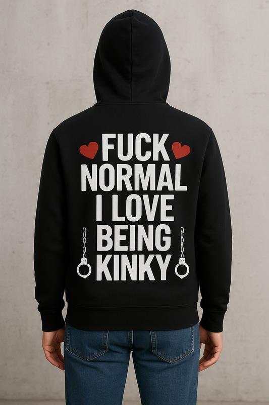 Persoon met rug naar de camera draagt een zwarte hoodie met gedurfde witte en rode tekst: 'FUCK NORMAL I LOVE BEING KINKY', afgewerkt met hartjes en handboeien, tegen een ruwe betonnen achtergrond.
